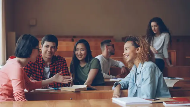 Estudiantes conversando en un aula universitaria