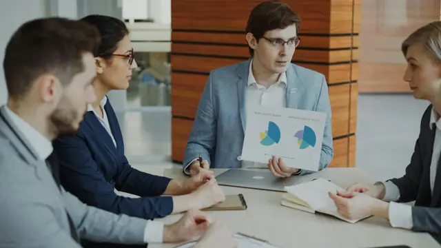 Equipo de trabajo revisando gráficas en una reunión de negocio